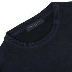 Close-up image of the Navy Blue Melange Merino Wool Crewneck, crafted by knitwear specialists from luxurious merino wool, featuring a label with "DANIELE FIESOLI" sewn on the inside neckline.