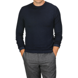 A person wearing a Navy Blue Melange Merino Wool Crewneck by Daniele Fiesoli and gray pants, with their hands in the pockets of their pants. The head is cropped out of the image.