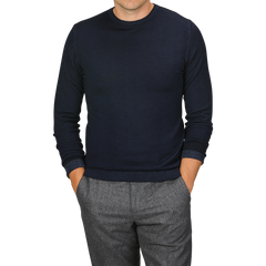 A person wearing a Navy Blue Melange Merino Wool Crewneck by Daniele Fiesoli and gray pants, with their hands in the pockets of their pants. The head is cropped out of the image.