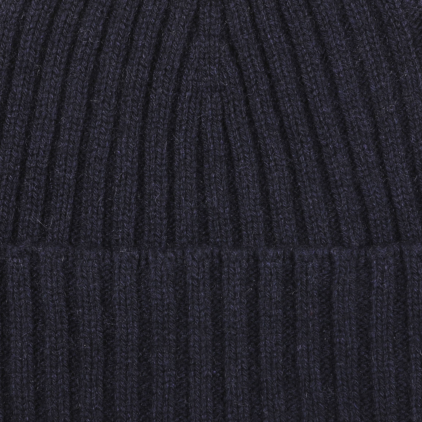 Close-up of a navy blue cashmere beanie with vertical ribbed texture by Daniele Fiesoli.