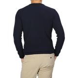 A person stands with their back to the camera, donning a Navy Blue Wool Cashmere Crewneck from Daniele Fiesoli and beige pants.