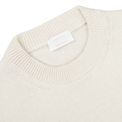 Close-up of the Nuvola Ecru Cashmere Crewneck Sweater by Daniele Fiesoli, crafted with upcycled cashmere, showcasing a ribbed neckline and a visible label inside proudly stating "made in Italy.