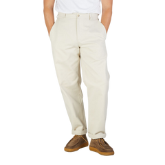 A close-up of a person wearing De Bonne Facture's Undyed Heavy Cotton Drill Balloon Trousers and brown suede shoes, standing against a plain background.