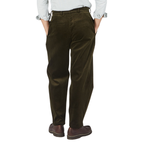 The back view of a man wearing Dark Olive Cotton Corduroy Balloon Trousers made by De Bonne Facture.