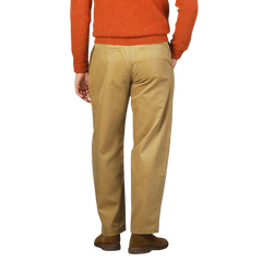 Person wearing a burnt orange sweater and De Bonne Facture Gold Mustard Cotton Corduroy Balloon Trousers, standing with their back facing the camera against a plain background.