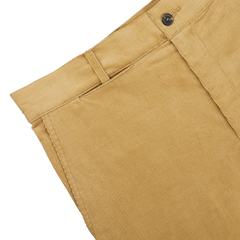 Close-up of De Bonne Facture's Gold Mustard Cotton Corduroy Balloon Trousers, featuring a waistband with a belt loop and button closure—perfect workwear pieces for any wardrobe.