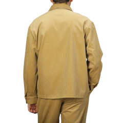 A person is shown from the back against a plain background, wearing a De Bonne Facture Gold Mustard Cotton Corduroy Work Jacket and matching pants.