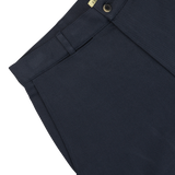 Close-up of De Bonne Facture navy blue heavy cotton drill balloon trousers, showing detailed texture and a button closure in heavy cotton drill fabric.