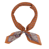 A neatly tied Sienna Brown Paisley Cotton Voile Bandana from De Bonne Facture displayed against a white background.