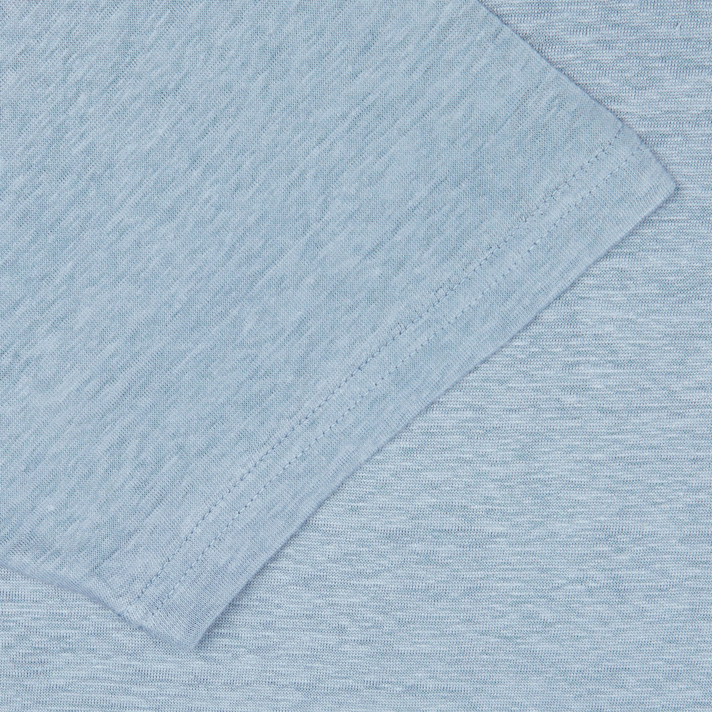 Close-up of a Smoke Blue Linen Jersey Oversized T-shirt from De Bonne Facture with visible weave patterns and a folded edge.