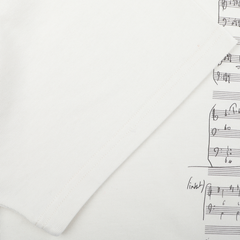 Close-up of a De Bonne Facture Undyed Printed Cotton Jersey T-Shirt, featuring an oversized design made from organic cotton jersey with musical notes and annotations printed on it.