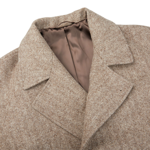 A close up of a De Bonne Facture Undyed Wool Herringbone Grandad Coat.