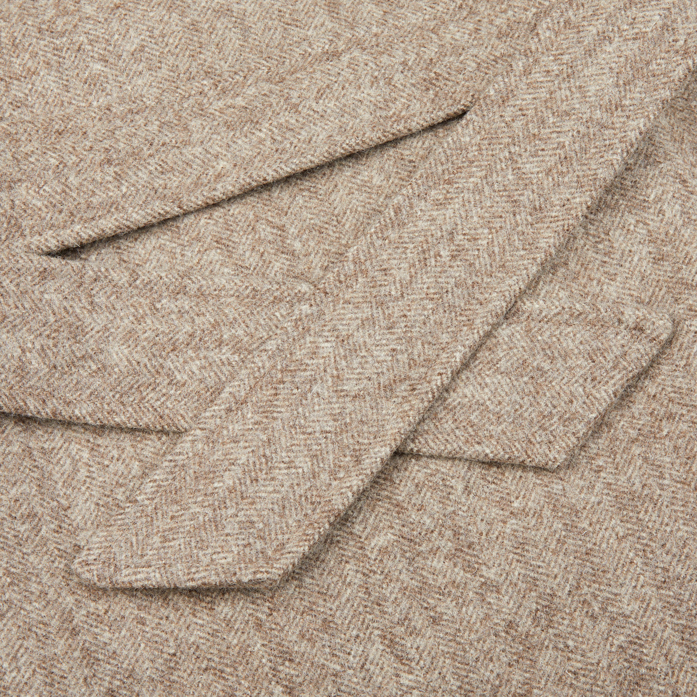 A close up image of a De Bonne Facture Undyed Wool Herringbone Grandad Coat.