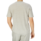 Rear view of a person wearing a De Bonne Facture Oatmeal Beige Linen Jersey Oversized T-shirt and matching gray sweatpants, standing against a transparent background.
