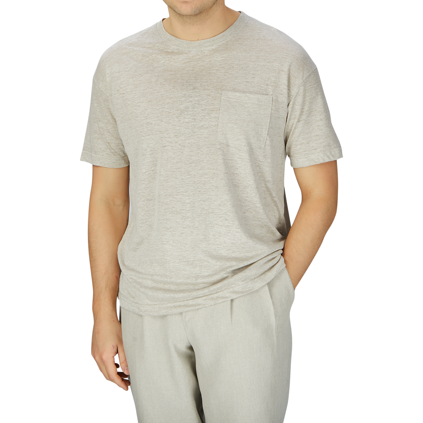 Man wearing an oversized Oatmeal Beige Linen Jersey T-shirt with a pocket and matching sweatpants by De Bonne Facture on a plain background.
