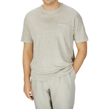 Man wearing an oversized Oatmeal Beige Linen Jersey T-shirt with a pocket and matching sweatpants by De Bonne Facture on a plain background.