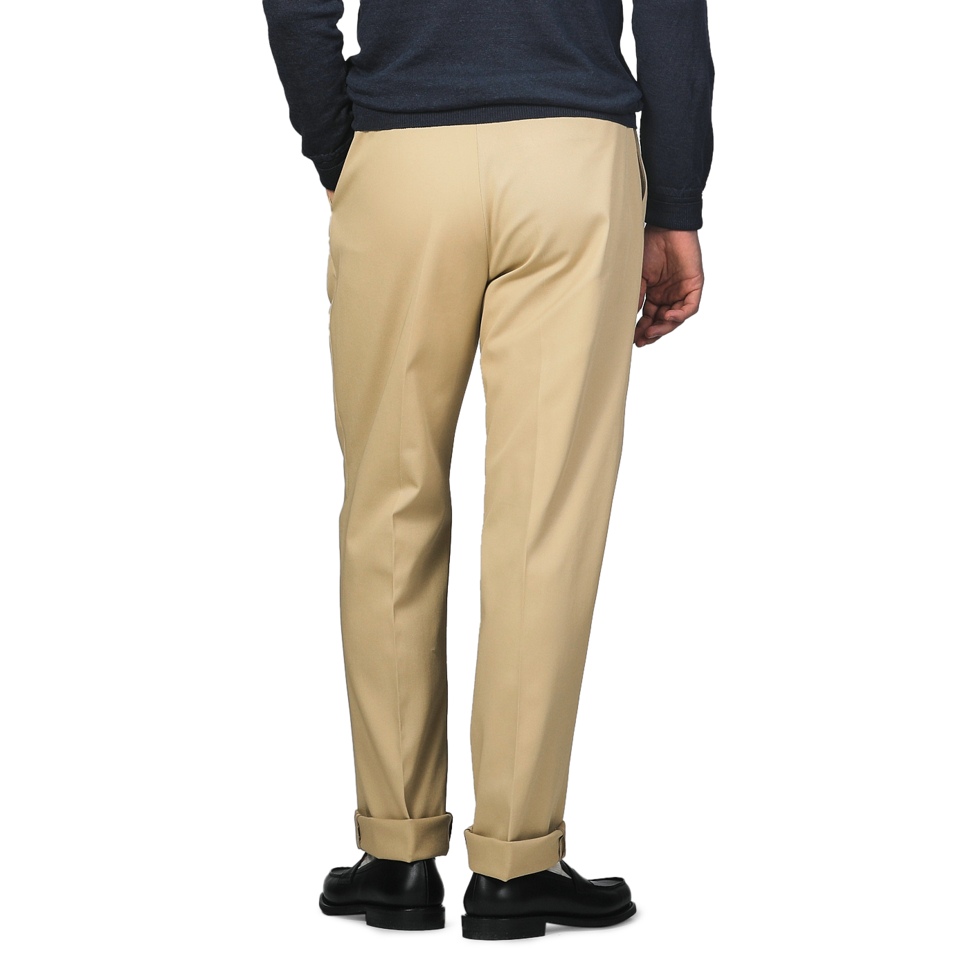 A person in a navy sweater and De Petrillo Beige Cotton Twill Modello E Trousers stands with hands in pockets, viewed from behind.