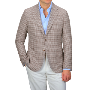 A person wears a De Petrillo Brown Houndstooth Wool Linen Posillipo Blazer over a light blue shirt, paired with white pants.