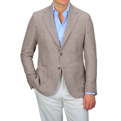 A person wears a De Petrillo Brown Houndstooth Wool Linen Posillipo Blazer over a light blue shirt, paired with white pants.