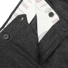 Close-up of the Charcoal Grey Wool Flannel Modello E Trousers by De Petrillo, highlighting the black buttons and zipper, with a white and striped inner lining.