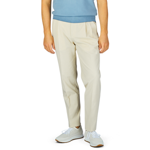 Man wearing slim fit casual De Petrillo Cream Cotton Seersucker Drawstring Trousers and white sneakers standing against a neutral background.