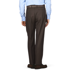 A person wearing a light blue shirt and De Petrillo's Dark Brown Wool Twill Modello E Trousers stands facing away.