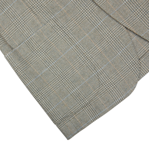 Folded fabric with a herringbone pattern on a geometrically patterned background, epitomizing contemporary tailoring for a De Petrillo Green Checked Wool Cotton Cashmere Posillipo Blazer.