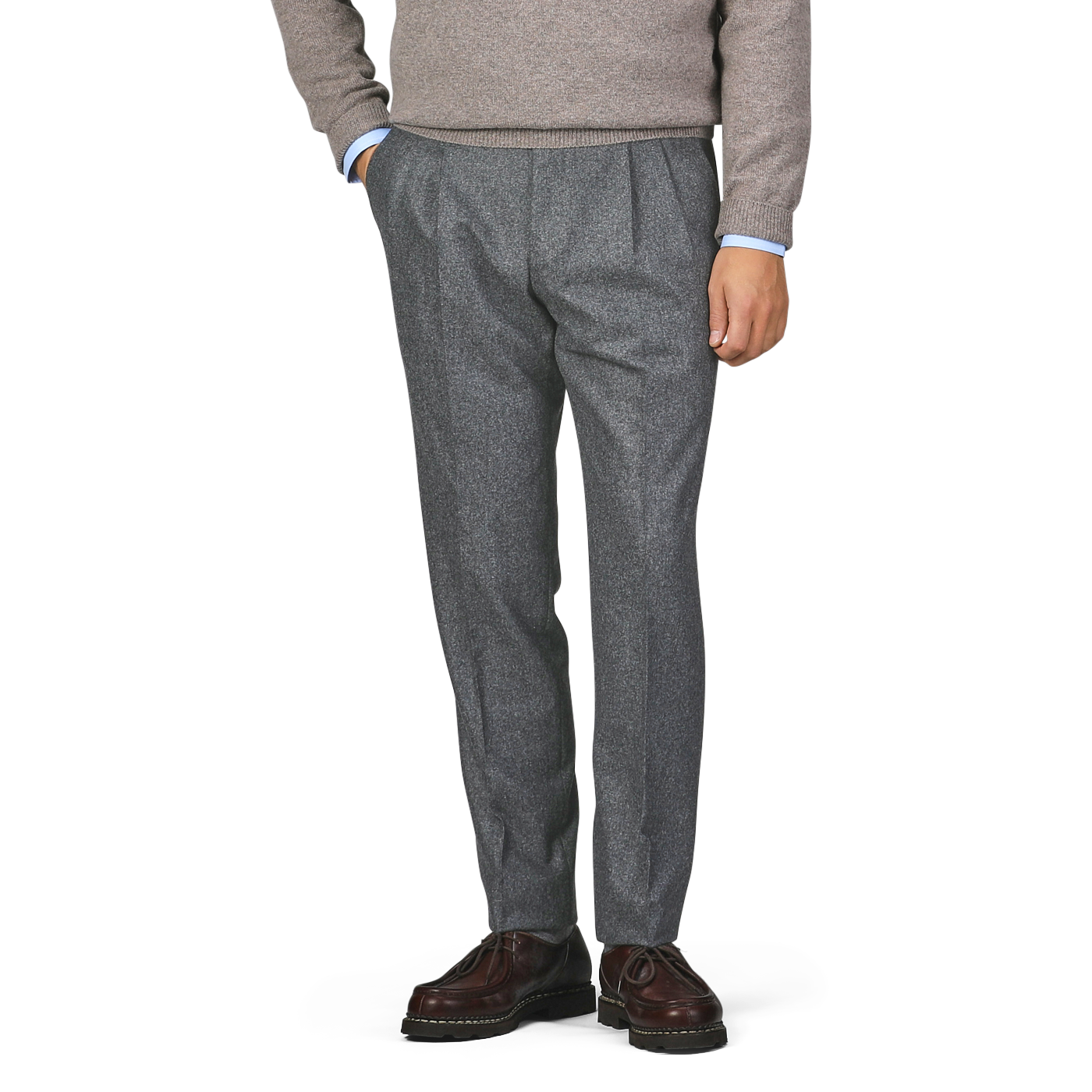 A person dressed in a gray sweater, De Petrillo's Medium Grey Wool Flannel Modello B Trousers, and dark brown shoes stands with their hands in their pockets.