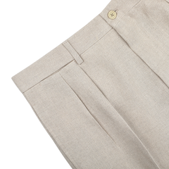 De Petrillo's Sand Beige Irish Linen Modello E Trousers boast a pleated design with button closure and belt loops, displayed elegantly on a light surface.