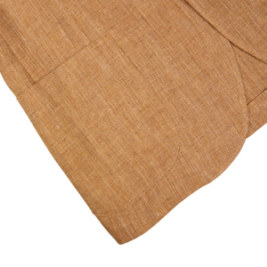 Close-up of a De Petrillo Tobacco Brown Herringbone Pure Linen Suit with folded edges on a white background.
