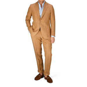 A person wearing a De Petrillo Tobacco Brown Herringbone Pure Linen Suit with a white shirt and brown shoes.