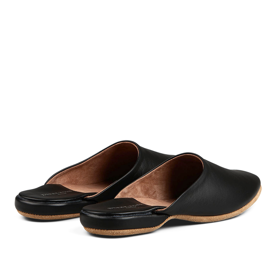 A pair of black, handmade leather slip-on shoes with a tan interior, displayed on a black background. 

Replace with: A pair of Derek Rose Black Leather Sheepskin Open Slippers with a tan interior displayed on a black background.