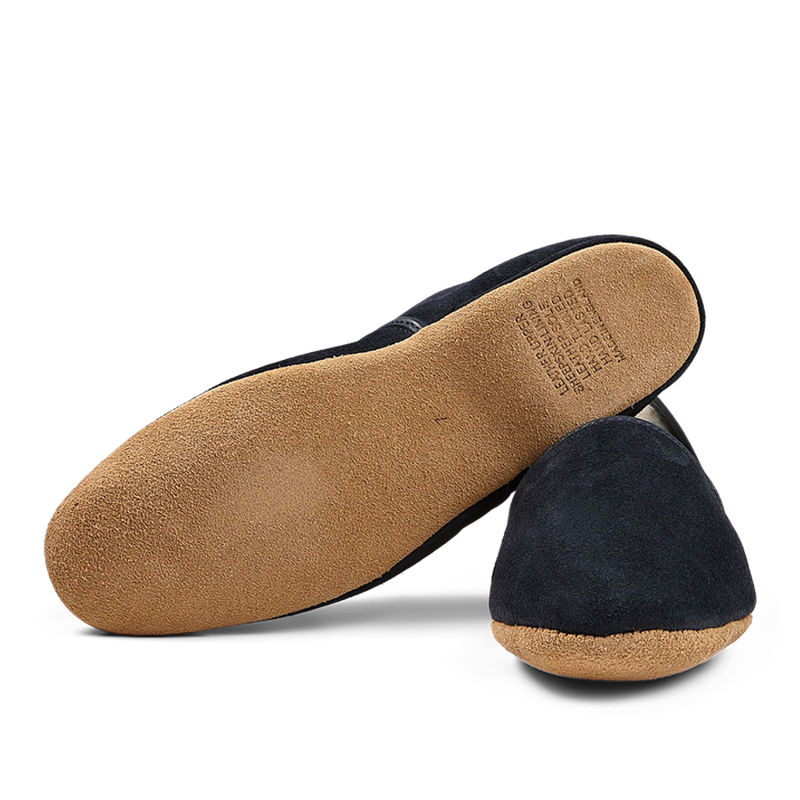 A pair of Navy Suede Sheepskin Closed-Back Slippers by Derek Rose with a soft sole displayed on a black background.