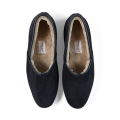 A pair of handmade Navy Suede Sheepskin Closed-Back Slippers from Derek Rose against a black background.