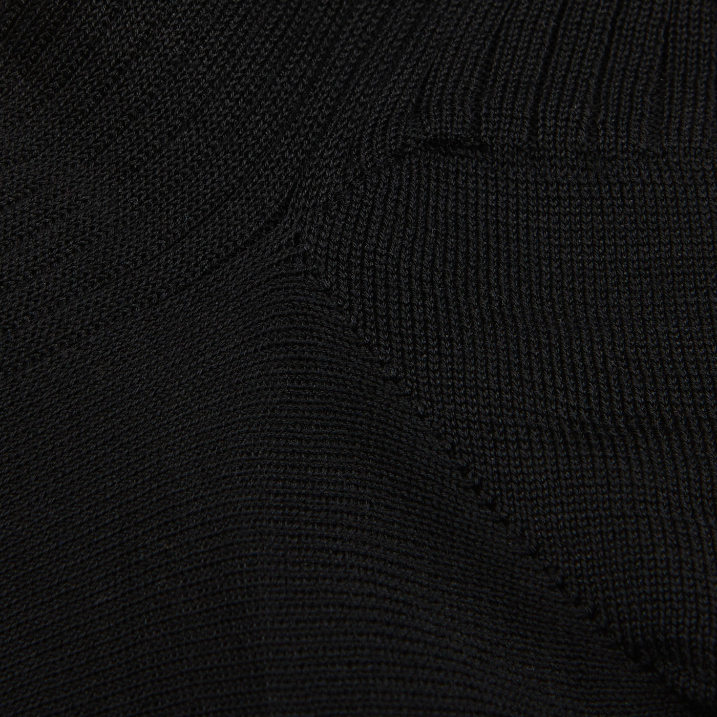 Close-up view of a black Doré Doré Cotton Fil d'Ècosse Ribbed Socks, showing detailed weave pattern with varying textures and stitch styles.