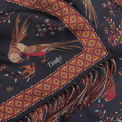 A close-up of the Navy Birds of Paradise Print Tubular Silk Scarf reveals a bird and floral pattern in red and brown hues on a dark background, featuring fringed edges and emblazoned with "Drake's," expertly crafted from luxurious silk in Como, Italy.