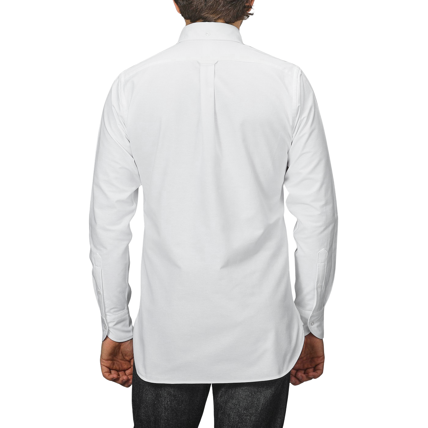 A person, viewed from behind against a gray background, wears Drake's White Classic Cotton Oxford BD Shirt with dark pants, epitomizing the classic elegance of British handmade garments.