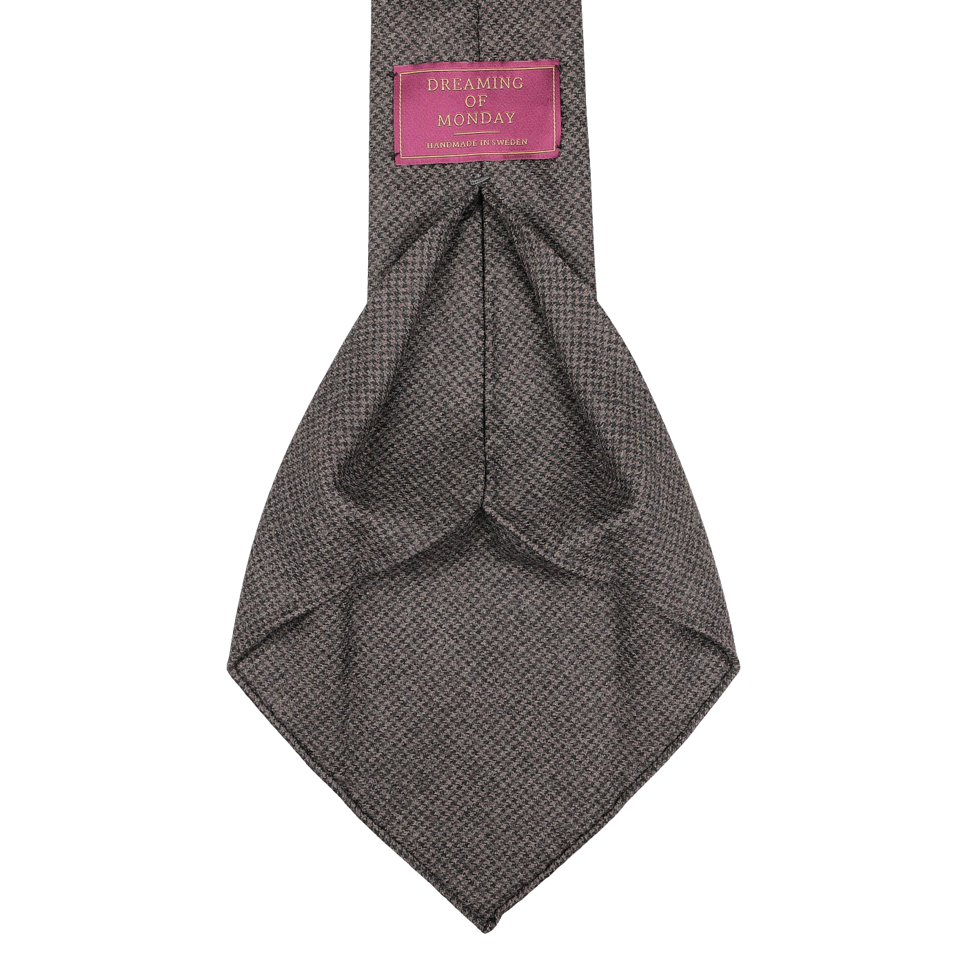 A Dark Brown Dogtooth 7-Fold Wool Flannel Tie, handmade in Sweden, featuring the Dreaming Of Monday pink label stitched on the back.