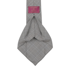 The Grey Blue Glen Plaid 7-Fold Vintage Wool Tie, handmade in Sweden, features a label with the text "Dreaming Of Monday" in pink and white.