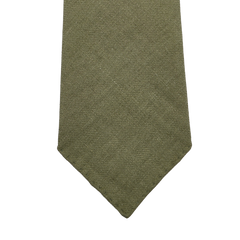 The Jardin Provençal Green 7-Fold French Linen Tie by Dreaming Of Monday is handmade with a textured olive hue and has a classic pointed tip.