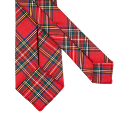 A handmade Red Royal Stewart Tartan 7-Fold Wool Tie by Dreaming Of Monday on a white surface.