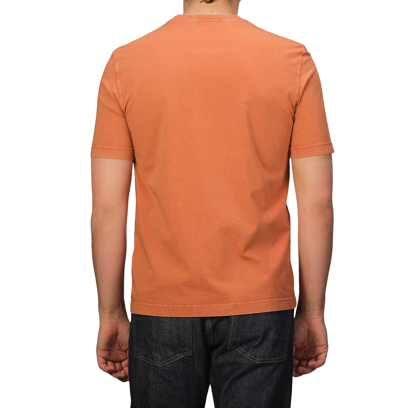 A person wearing Drumohr's Burnt Orange Washed Cotton T-Shirt paired with dark jeans, highlighting its slim fit, stands against a plain background.