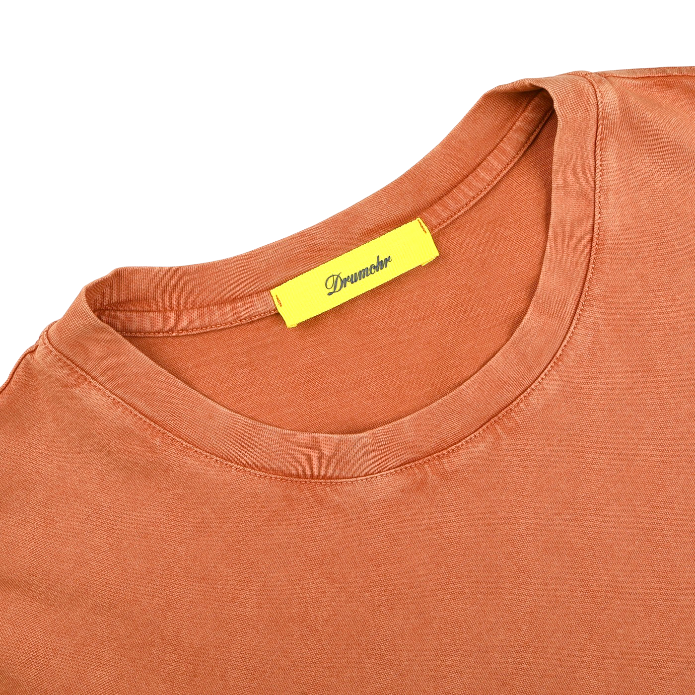 The Drumohr Burnt Orange Washed Cotton T-Shirt is a slim fit, terracotta-hued tee with a yellow "Dreamher" tag. Made in Italy, this stylish crew neck effortlessly combines comfort and elegance.