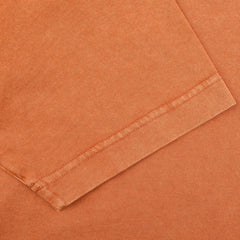 Close-up of a folded sleeve hem on a Drumohr Burnt Orange Washed Cotton T-Shirt, highlighting the stitching detail. Made in Italy, this piece exemplifies impeccable craftsmanship.