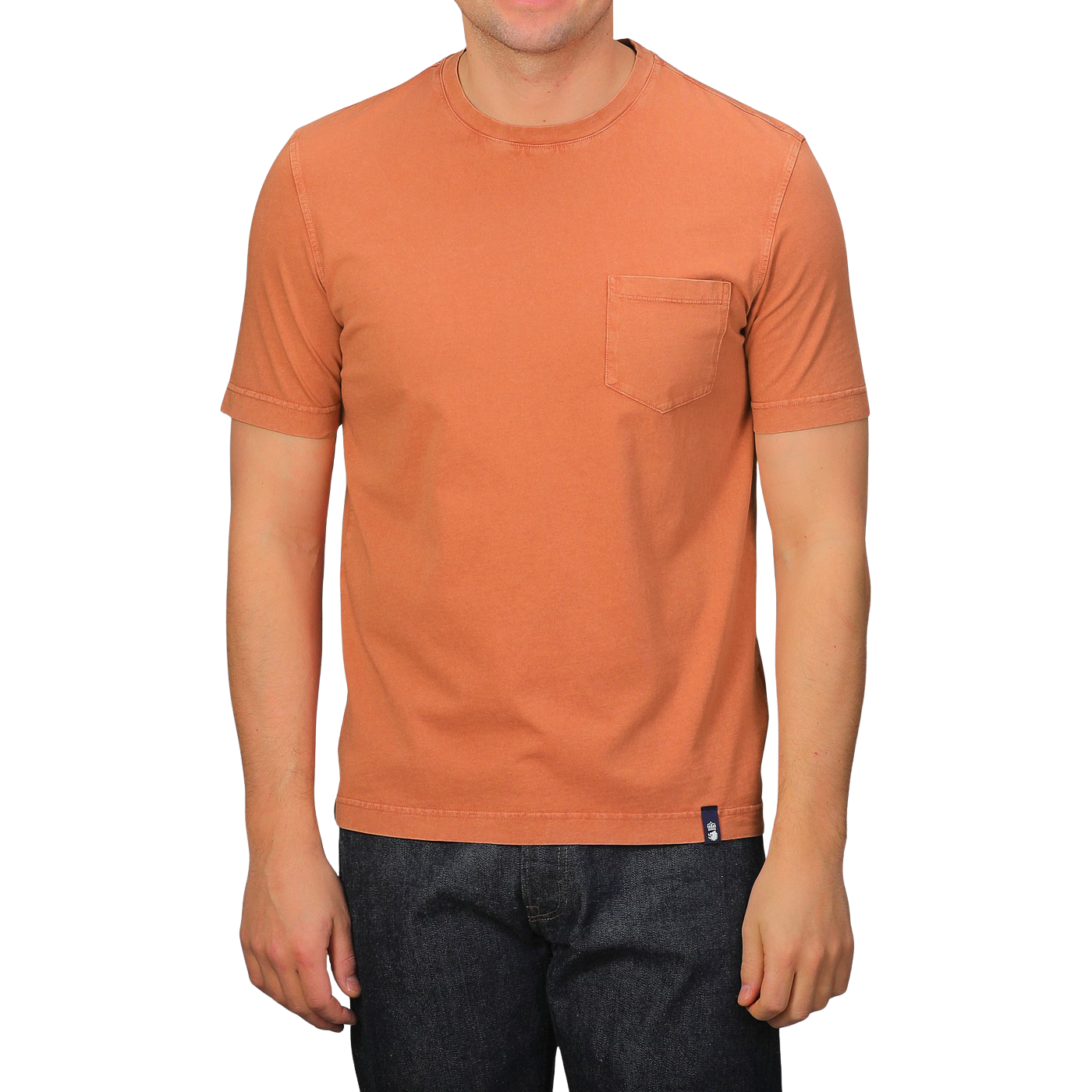 A person dons a Drumohr Burnt Orange Washed Cotton T-Shirt, featuring a slim fit and chest pocket, crafted in Italy, paired with dark jeans.