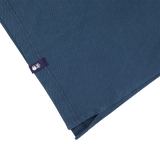 A Drumohr blue blanket with a purple tag attached.