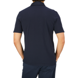 A man seen from behind wearing a dark blue Drumohr Navy Blue Cotton Piquet Polo Shirt and matching pants.