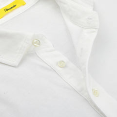 Close-up of Drumohr's off-white cotton pique polo shirt collar with buttons, highlighting a visible yellow label. The slim fit design provides a modern look and comfortable wear.