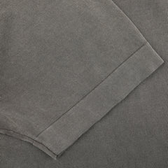 Close-up of a Drumohr Mole Washed Cotton Crepe Polo Shirt in gray, showcasing the texture and stitching details of this slim fit garment, with emphasis on the fold and hem.