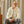 A man sitting on a chair wearing glasses and a Gran Sasso Ecru Rib Stitch Cotton Full-Zip Cardigan sweater.